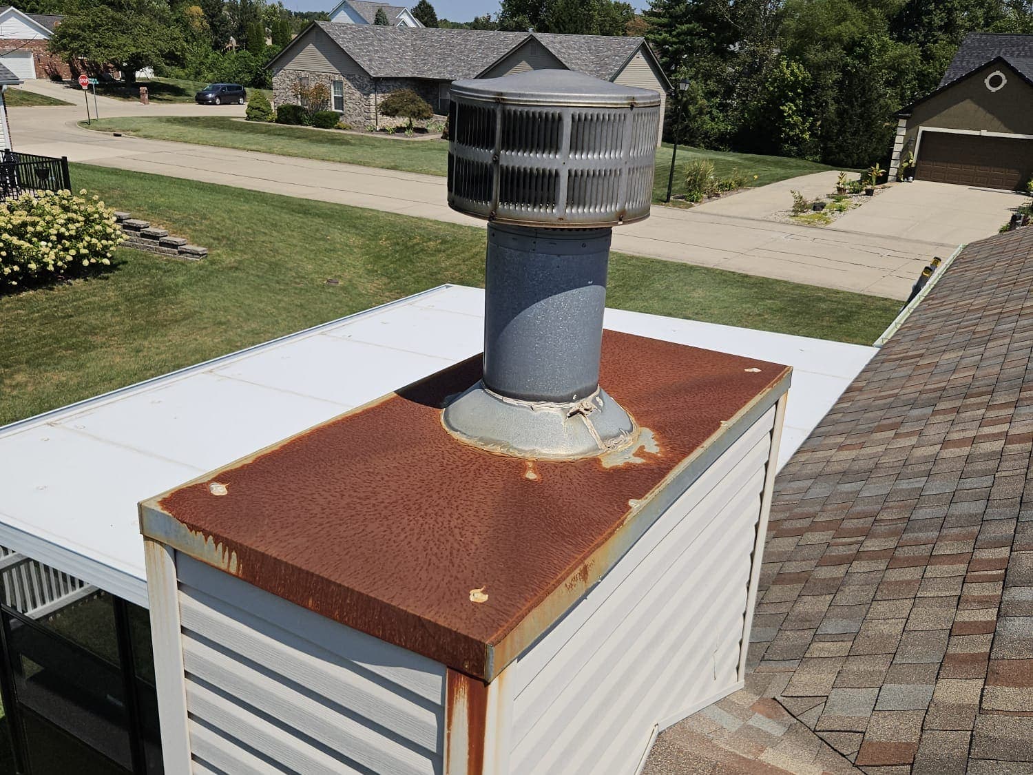 Corner view of a rusted galvanised chase cover, showing rust staining running down the corner trim of the chase